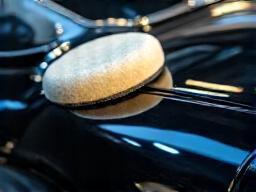 Waxing and polishing service on a luxury car surface